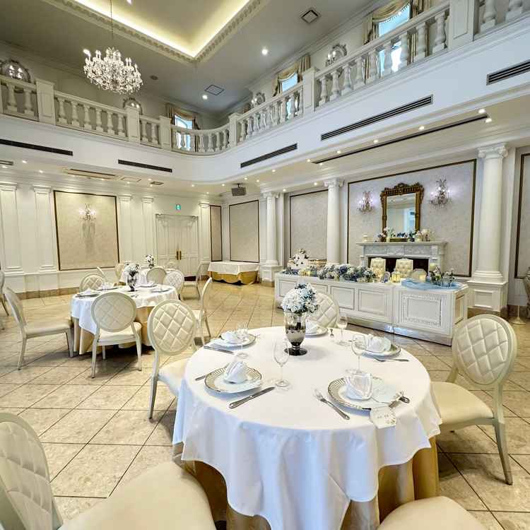 開放感のある、天井が高く、白基調の披露宴会場。高砂はソファとサイドテーブルの形に変更も可能とのこと。