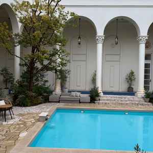 白を基調とした建物とプール付きガーデンの写真です。