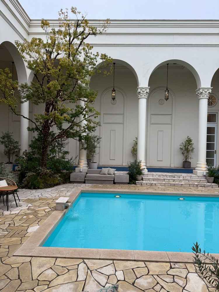 白を基調とした建物とプール付きガーデンの写真です。