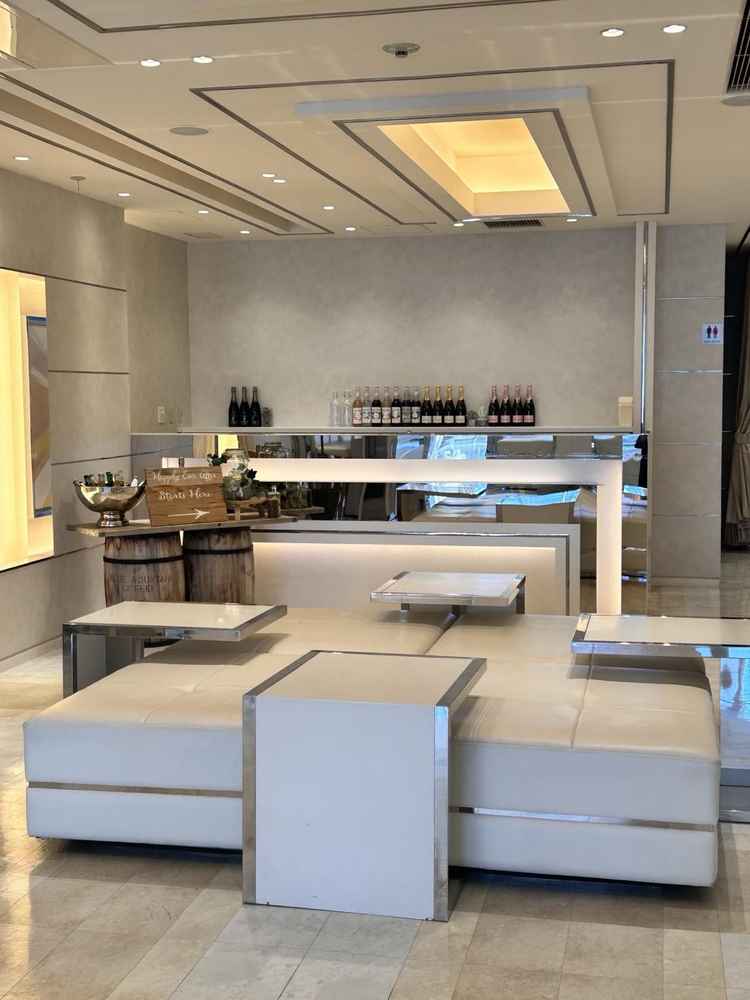 落ち着いた色合いのラウンジスペース。ソファとバーカウンターがあって白っぽい待合空間でした。