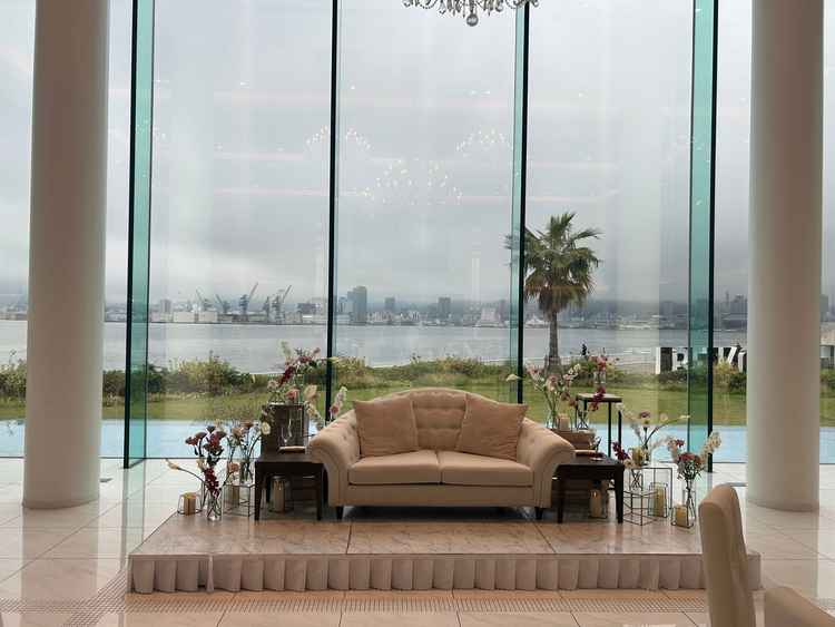 披露宴会場で新郎新婦が腰掛けるソファ。背後には海と神戸の街並みが見え、写真映えする。