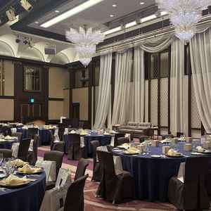 披露宴会場。天井が高く、シャンデリアや新郎新婦が座る席の後ろのカーテンが豪華に感じた。