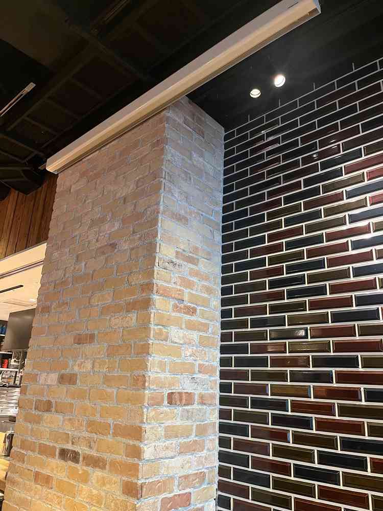 オープンキッチン横の壁とプロジェクター。映像を投影する場合はこちらを使う