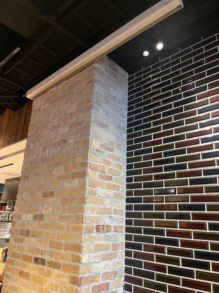 オープンキッチン横の壁とプロジェクター。映像を投影する場合はこちらを使う