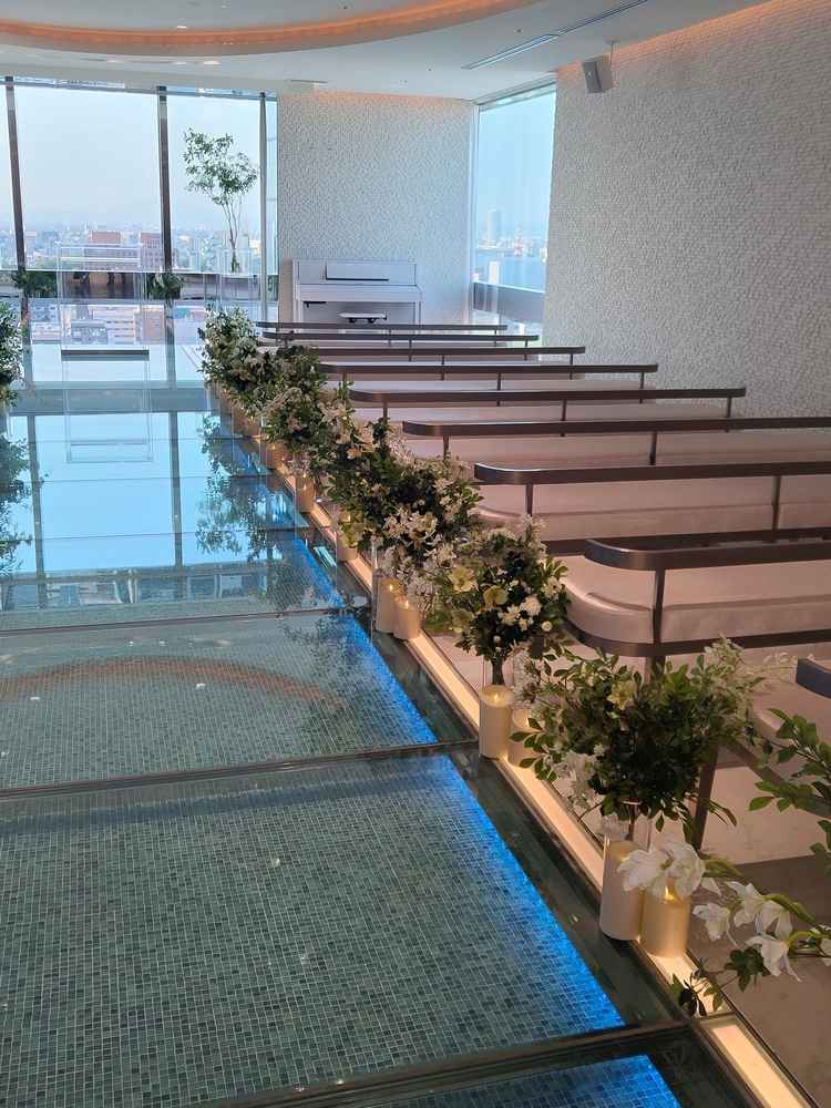 ガラス張りで水が流れているようなバージンロード。挙式の祭壇や椅子も全て透明でドレスが映える！