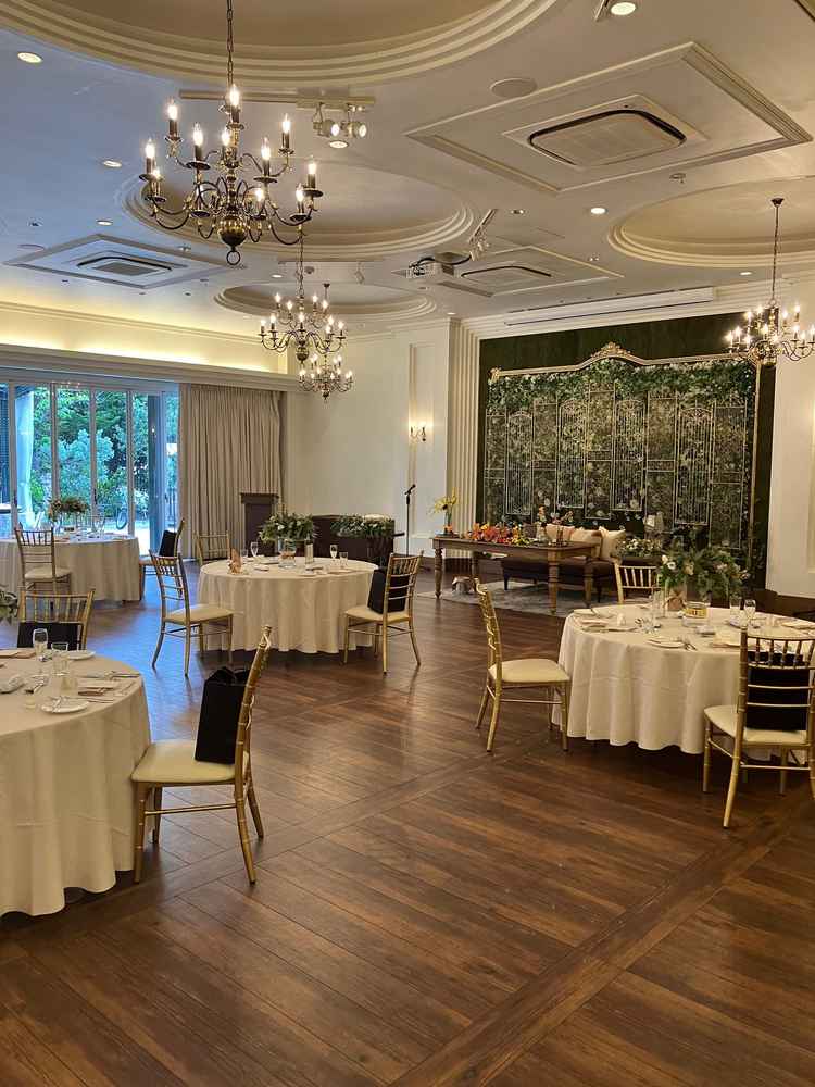 開放感のある披露宴会場で、複数のシャンデリアが輝き、落ち着いた品格を添えていました。