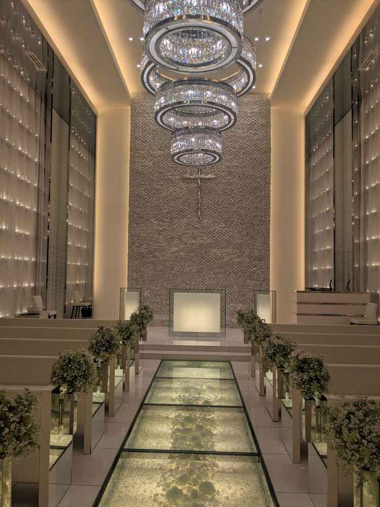 式場。床がガラス張りになっていて、壁一面にはキャンドル。白さが際立って明るいイメージでした。