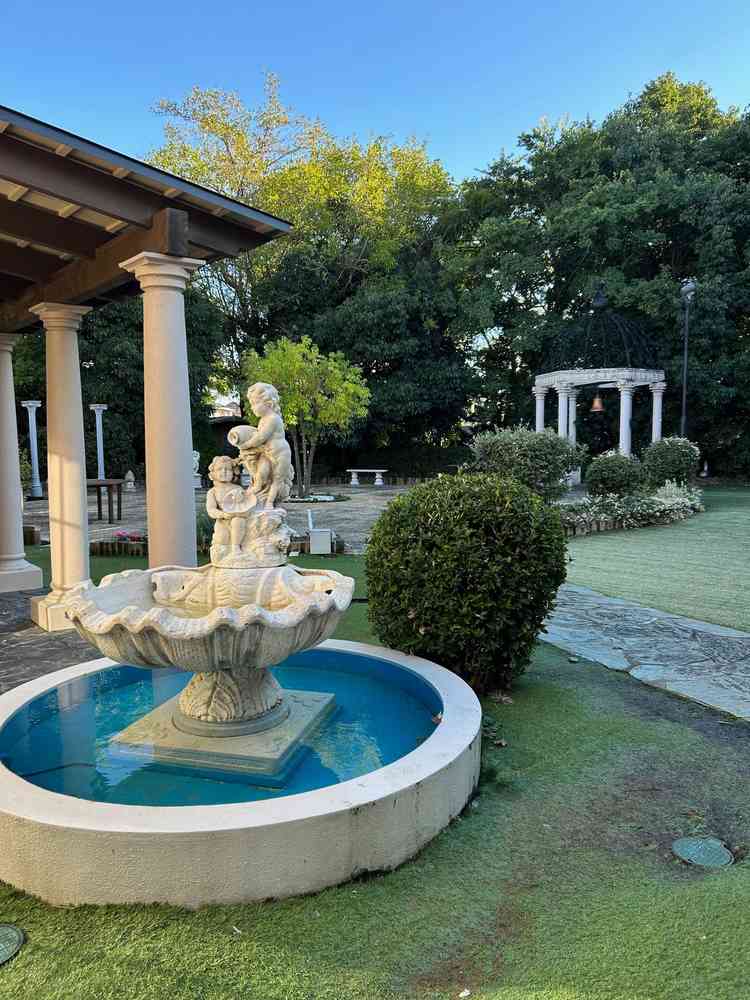 チャペルへ繋がる渡り廊下左手に見える中庭。噴水や鐘が置いてあり、爽やかな写真映えスポット。