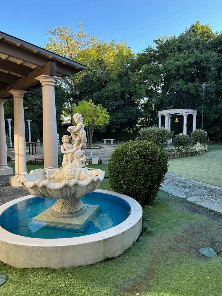 チャペルへ繋がる渡り廊下左手に見える中庭。噴水や鐘が置いてあり、爽やかな写真映えスポット。