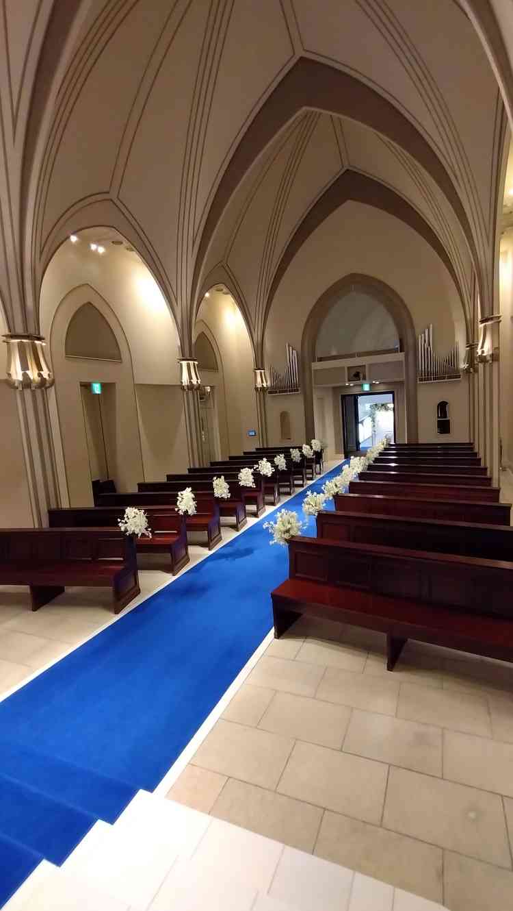 青のバージンロードは、実際に見ると青すぎず落ち着いていてよい印象。チャペルの天井も高い。