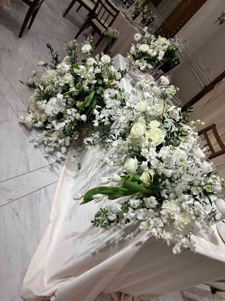 披露宴会場の高砂の写真。花のボリュームと色合いが素敵でした。