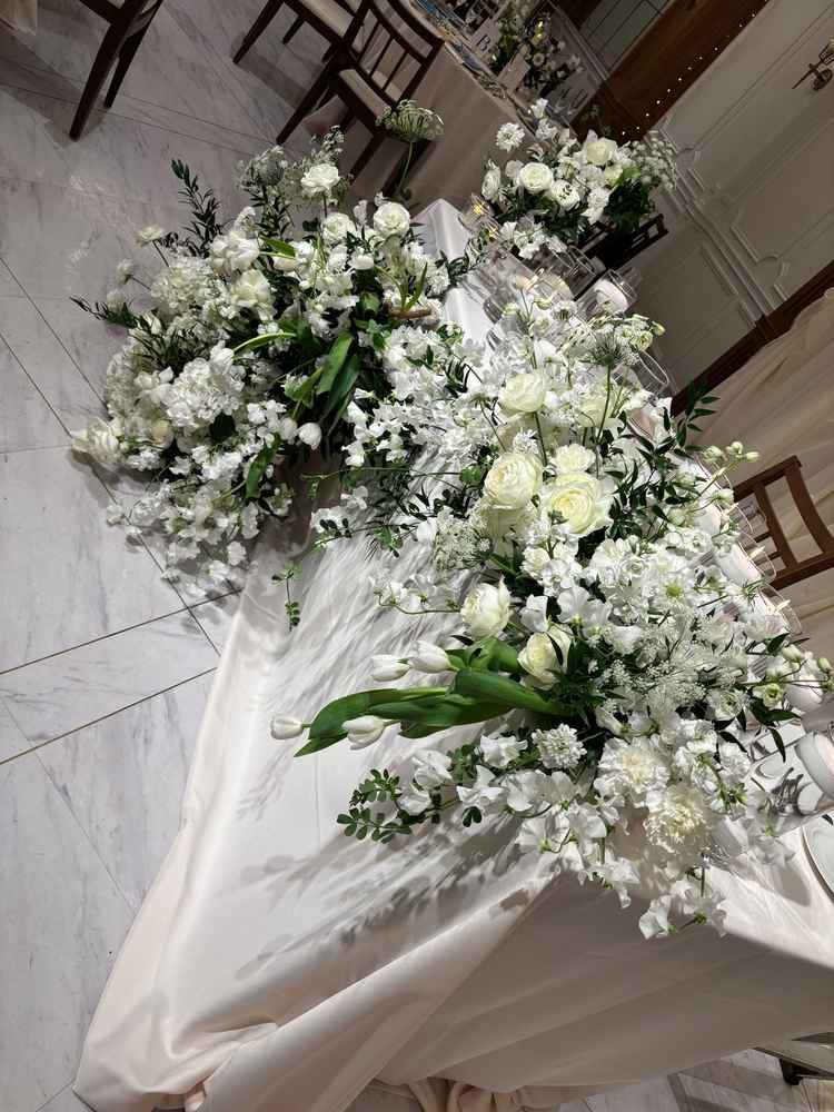 披露宴会場の高砂の写真。花のボリュームと色合いが素敵でした。