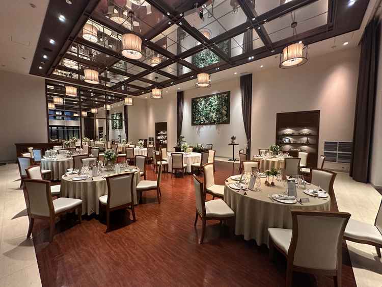 披露宴会場。左側面・上部が鏡張りで空間が広く見える。白/茶色の配色が非常に落ち着いた雰囲気。