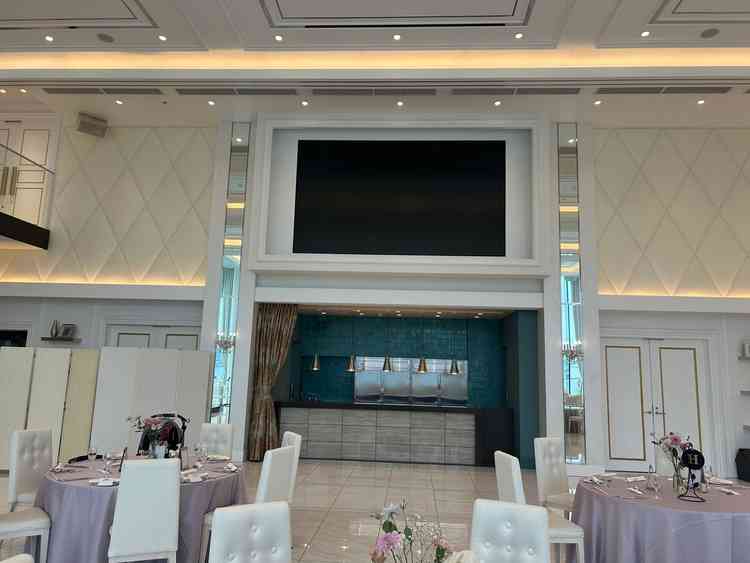 披露宴会場のスクリーンとオープンキッチン。目の前で調理されるため、熱々の料理がいただける。