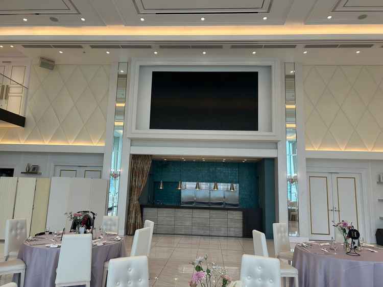 披露宴会場のスクリーンとオープンキッチン。目の前で調理されるため、熱々の料理がいただける。