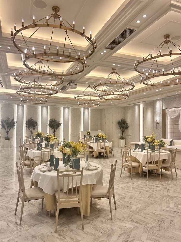 大きな丸いシャンデリアが印象的な披露宴会場。丸テーブルが並んでいました。