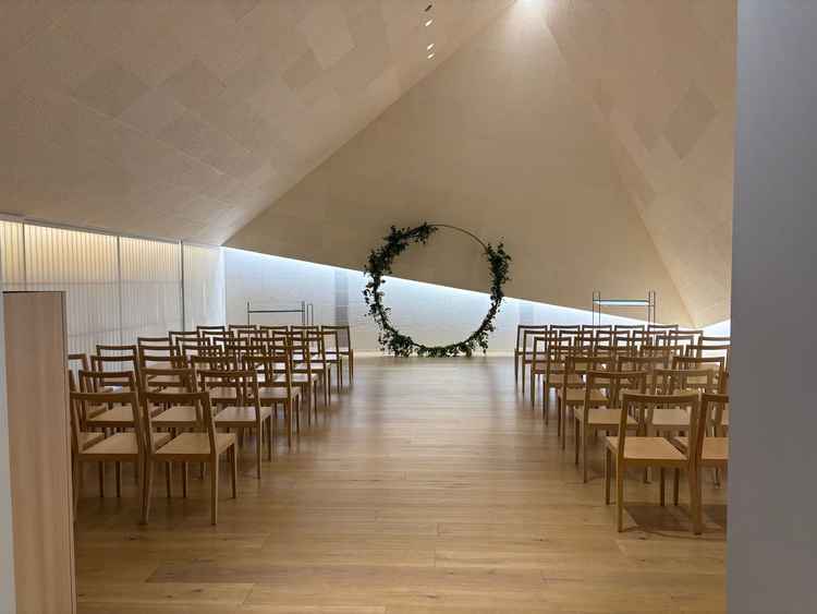 和紙が使われていて三角形が特徴のチャペル。木の椅子は温かみがある。