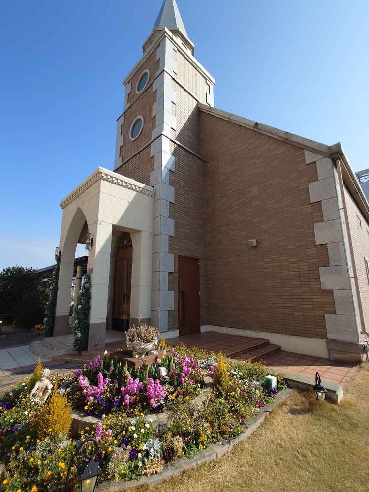 上にある独立のチャペル。レンガ建物、周りにお花と芝あり。