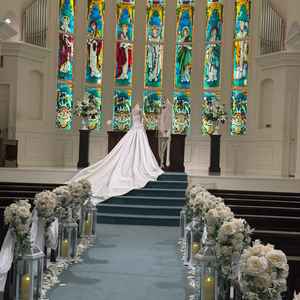 青いバージンロードに白い花達が飾られ爽やか。そこに鮮やかなステンドグラスがよく映えるチャペルでした。