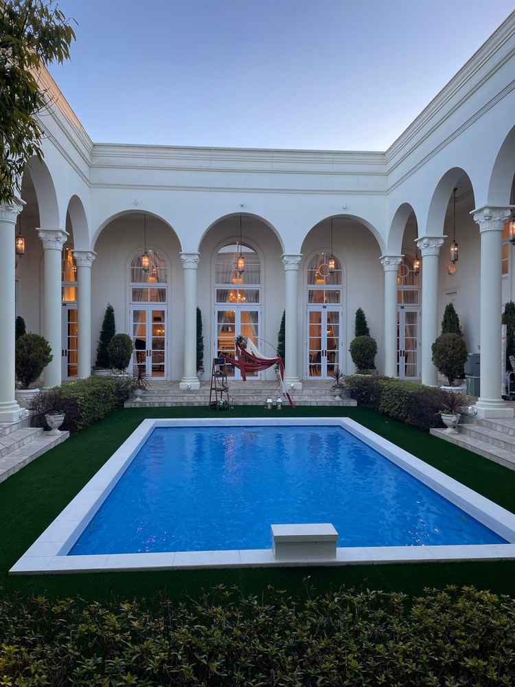 ヴィクトリアハウスの門を開けると、大きなプールがあり、アンティーク調の建物が魅力的です。