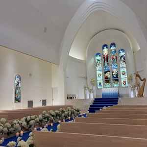 白い壁に青いカーペットが映えるチャペル。ステンドグラスが印象的でした。