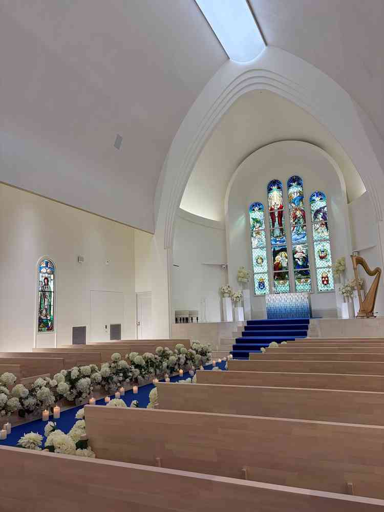 白い壁に青いカーペットが映えるチャペル。ステンドグラスが印象的でした。