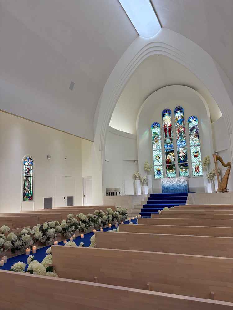 白い壁に青いカーペットが映えるチャペル。ステンドグラスが印象的でした。