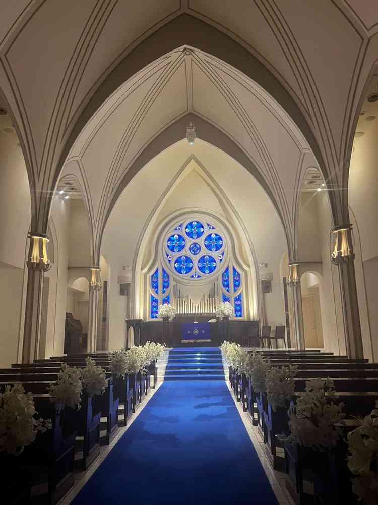 チャペルの写真です。ステンドグラスが印象的でカーペットの青色とマッチしており、高級感と重厚感を感じま