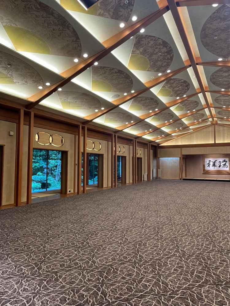 【披露宴会場】開放感のある空間と天井には末広がりをイメージした扇のデザインがあった。