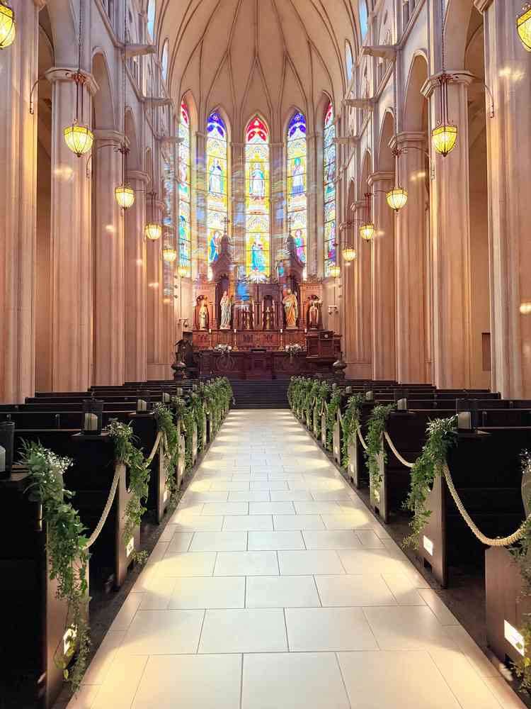 ステンドグラスが綺麗な挙式場。ウェディングドレスが映えるような少し色の濃い階段の色になっていました。