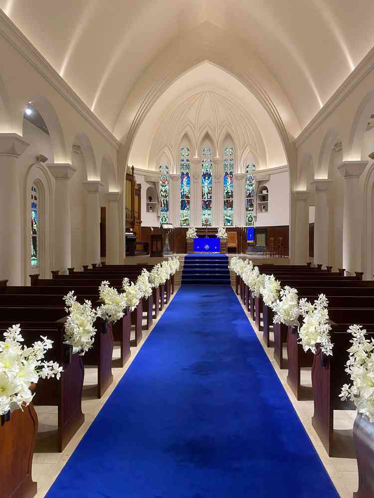 青のバージンロードが映えているかつステンドグラスで素敵でした。