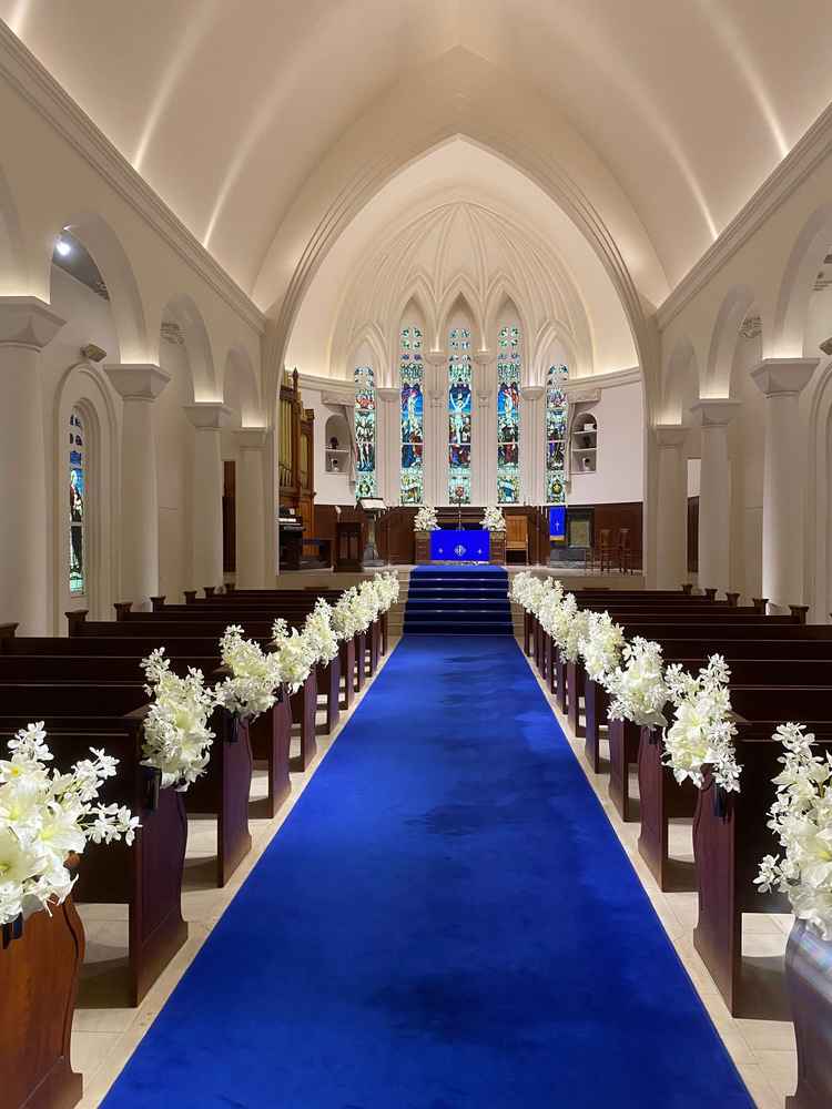 青のバージンロードが映えているかつステンドグラスで素敵でした。