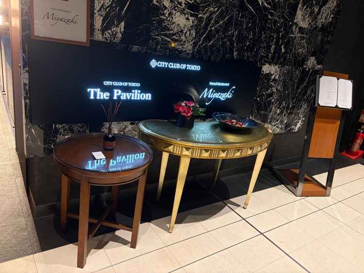 入口のエレベーターを降りた直後の案内板。当日シェフとなるレストランが併設されている。