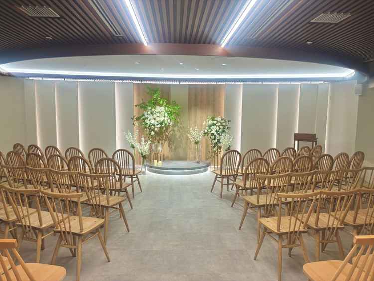 挙式会場。実際にセンターに立つのであればやや狭い、ドレスにもよるがお花の位置は変更しよう、という話。
