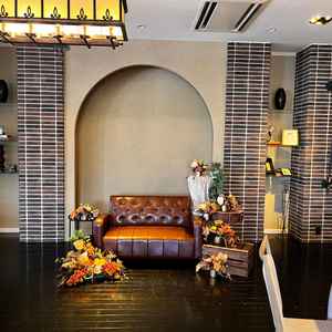 黒を基調とする披露宴会場の高砂の写真。ヴィンテージ感のあるソファが雰囲気を醸し出していた。