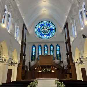 挙式会場の入ってすぐの写真。ステンドグラスの感じや周りの花が素敵でとても雰囲気が良いなと感じました。