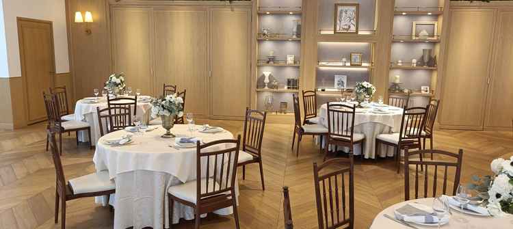 披露宴会場のゲスト席の写真です。全体的に木目調で温かく、落ち着いた雰囲気であると思いました。