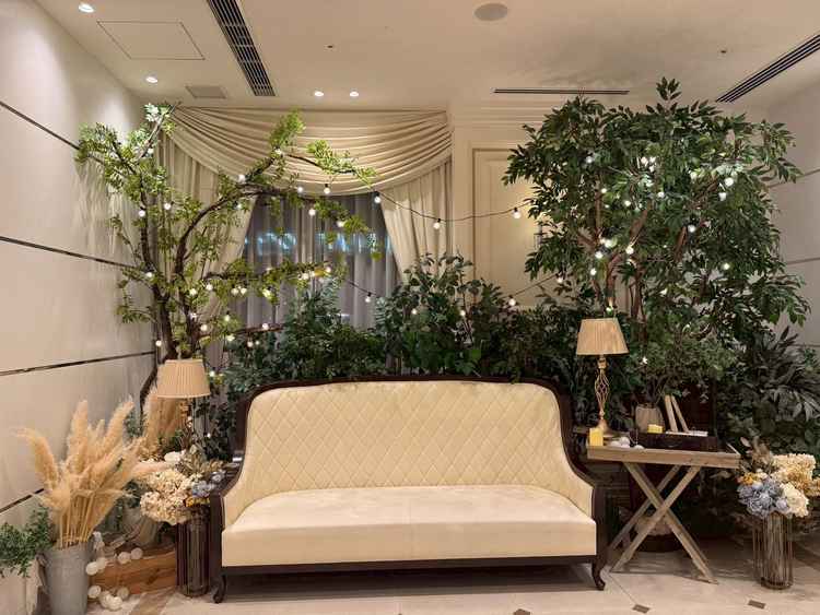 披露宴会場前には、グリーンとライトに囲まれたナチュラルで温かみのあるフォトスポット。