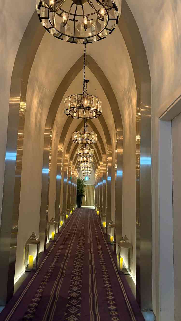 チャペルまでの廊下。厳かな雰囲気の照明と、床の両側に並んだ暖かみあるロウソク風のライトが素敵でした。