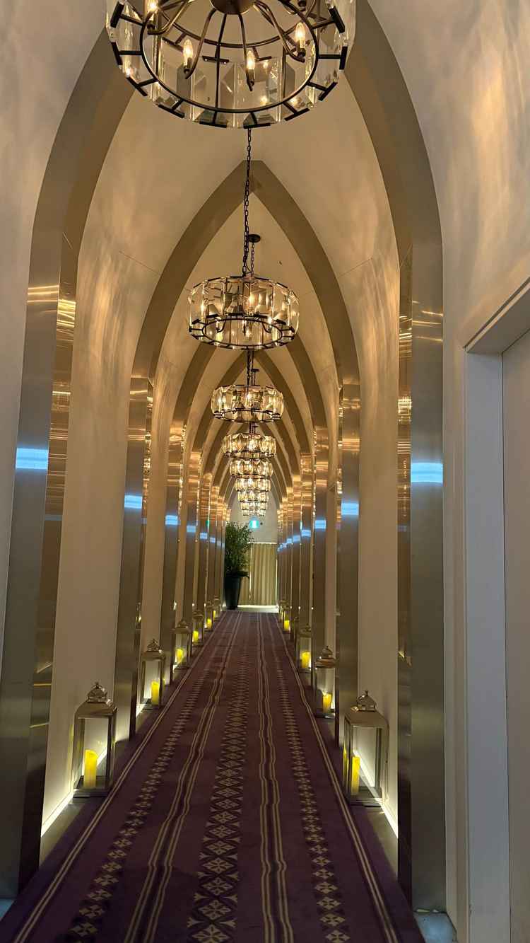 チャペルまでの廊下。厳かな雰囲気の照明と、床の両側に並んだ暖かみあるロウソク風のライトが素敵でした。