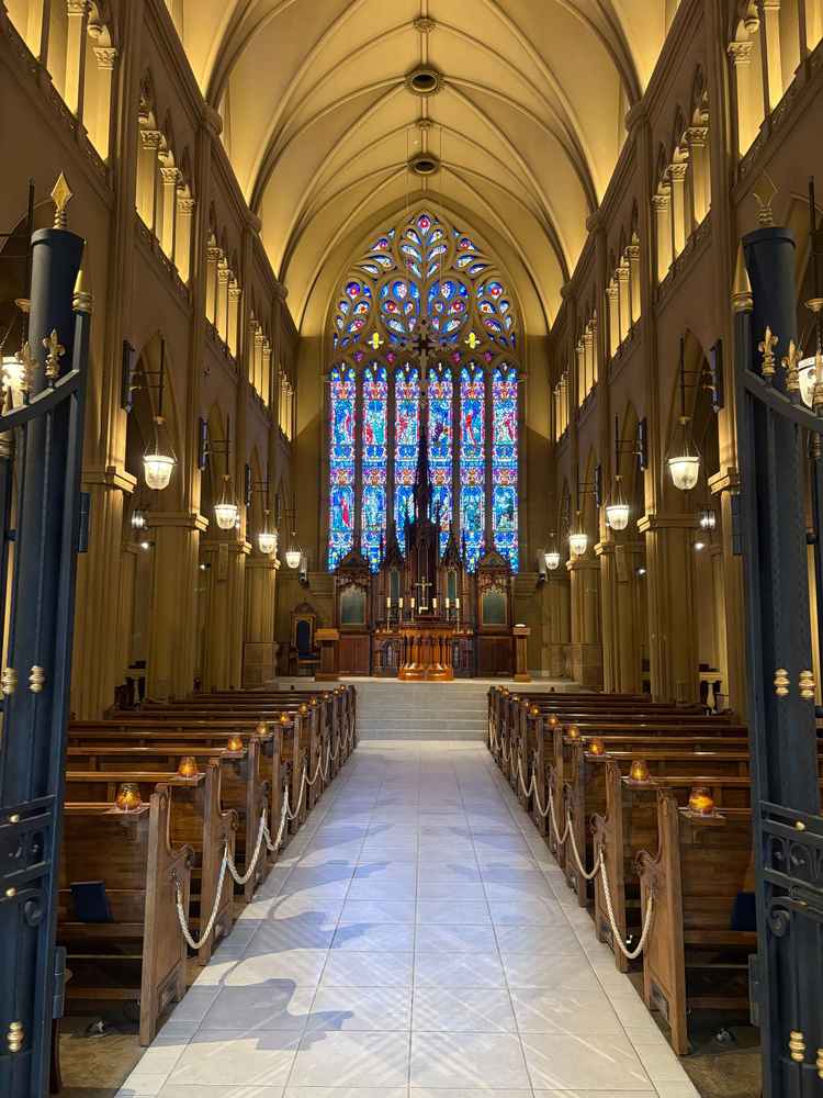 ステンドグラスが素敵な挙式会場。ブラウンを基調とした造りで、白のウエディングドレスがよく映える。