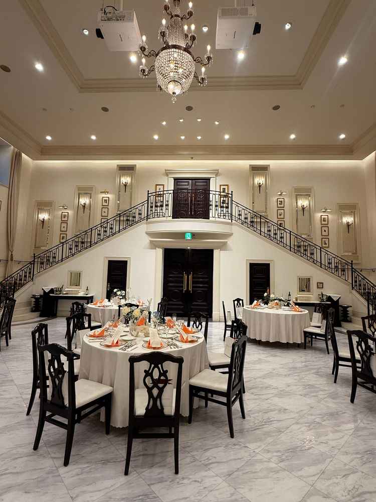 披露宴会場。白を基調にしており何色でも合いそう。階段が素敵。