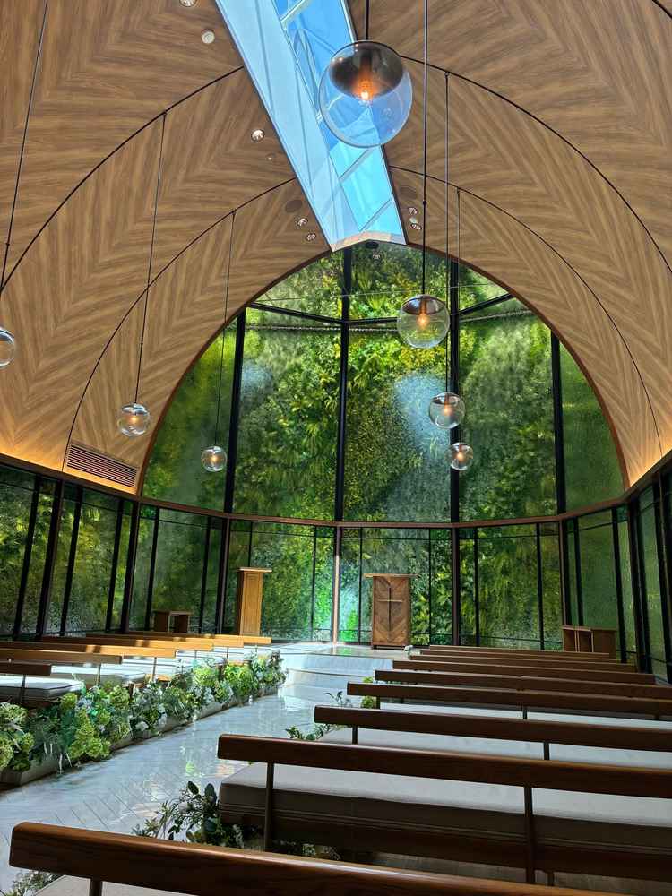 正面のグリーンウォールと自然光が印象的で、温かみがあり写真映えするチャペルでした。