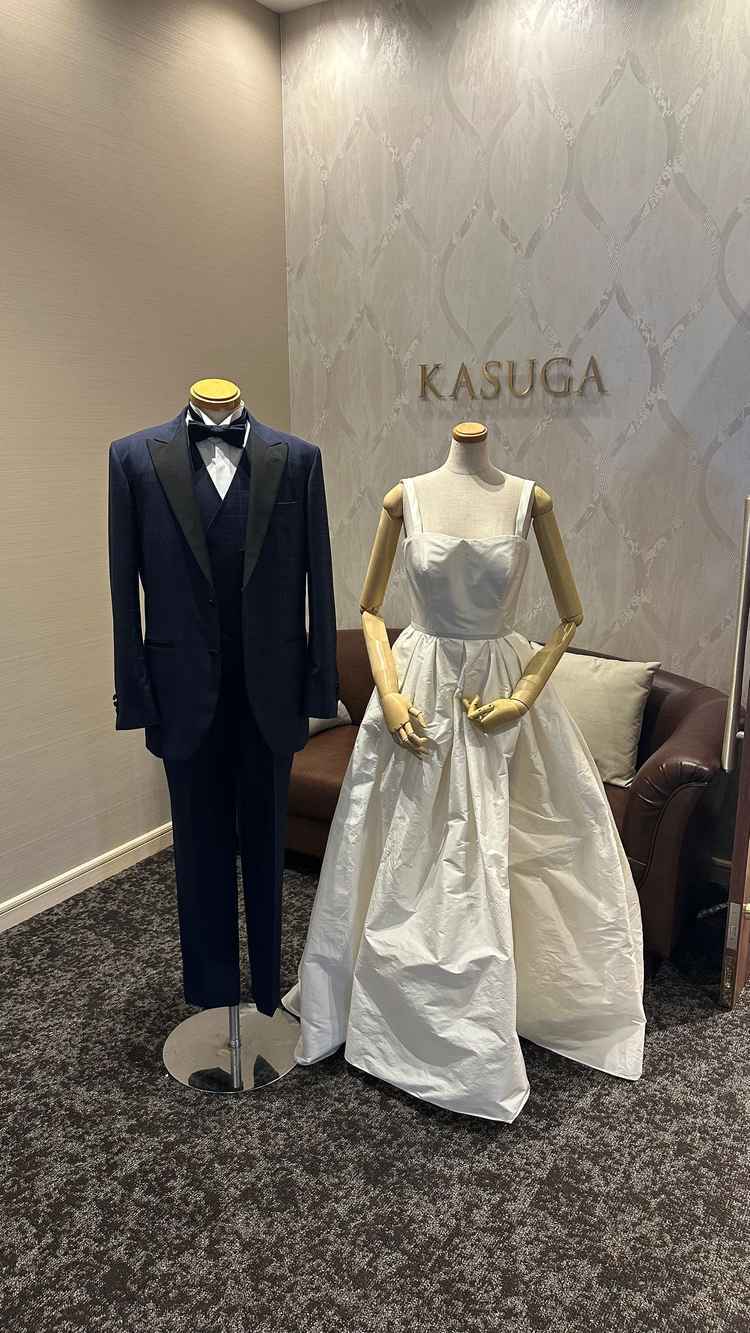 式場入り口にあるタキシードとウェディングドレスの写真。