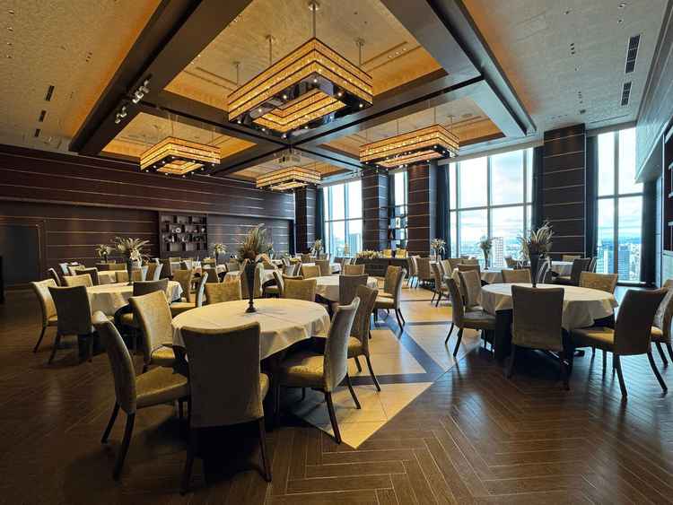 ホテルのような茶色基調にゴールドの空間。新郎新婦入場一礼後に高砂の後ろのカーテンが開く演出も素敵です