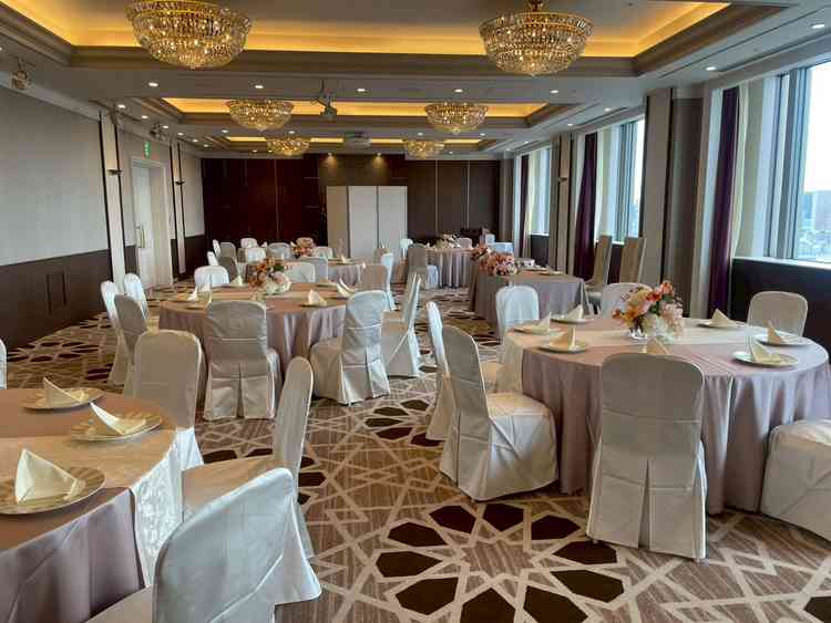 披露宴会場(小)の全景写真。色合いや照明から高級感を感じられる。