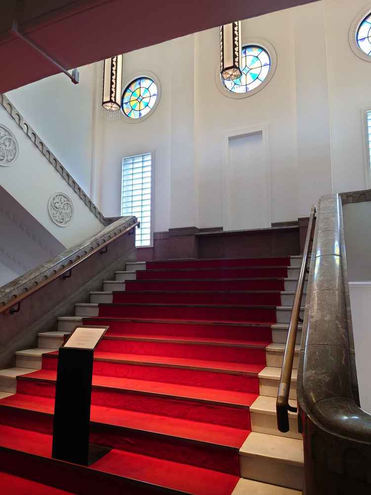 会場に入って正面の階段の写真で、ステンドグラスもあり素敵でした。