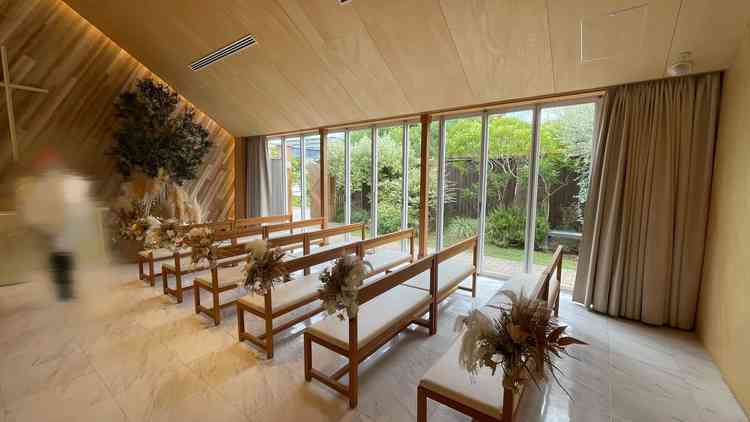 チャペルのカーテンを開けた状態。明るい光が入り、外の自然を感じ温かみを感じられる。