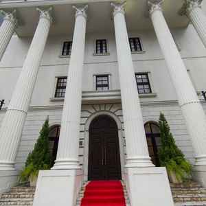 重厚感のある大きな柱と赤いバージンロードが目を引く、洋館風のエントランスです。