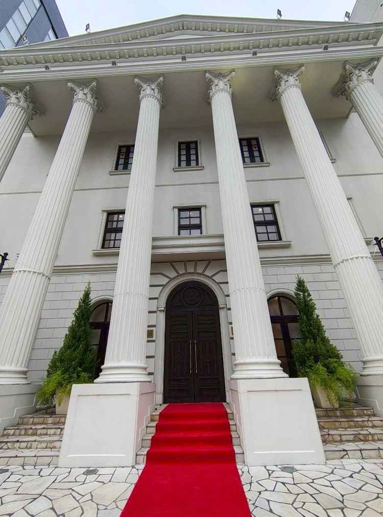 重厚感のある大きな柱と赤いバージンロードが目を引く、洋館風のエントランスです。